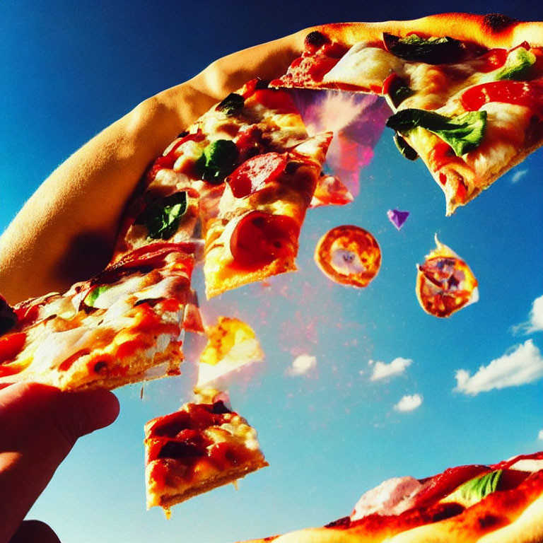 Hand holding pizza slice against blue sky with floating pieces and clouds