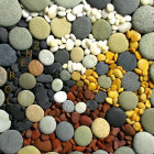 Vibrant pebbles with intricate designs on sandy surface