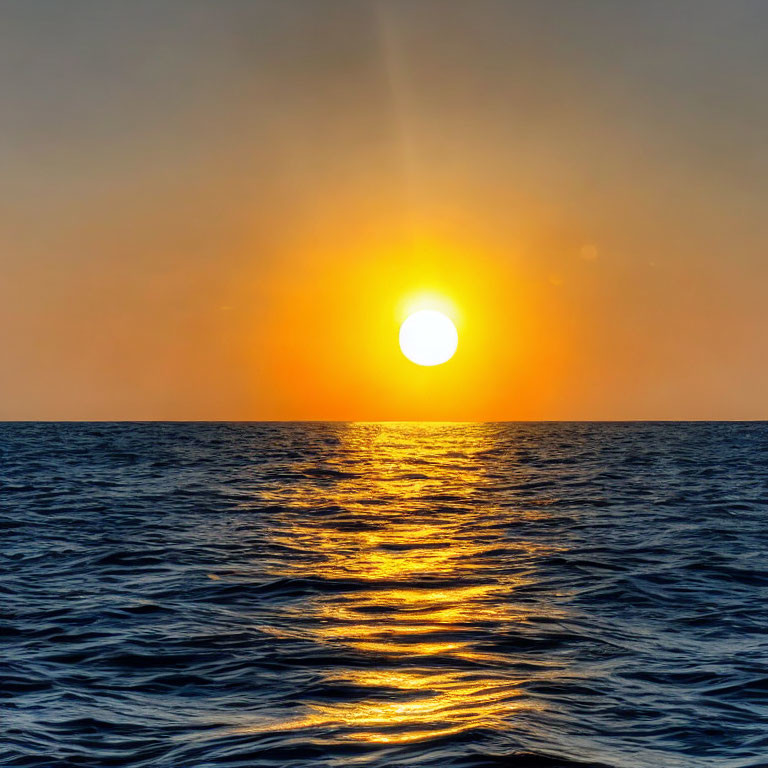 Vivid ocean sunset with sun's reflection on water