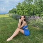 Woman in Blue Dress Sitting on Grass with Translucent Landscape Overlay