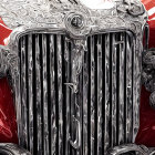 Stylized vintage car grille and headlights with red and white paint and ornate hood detailing