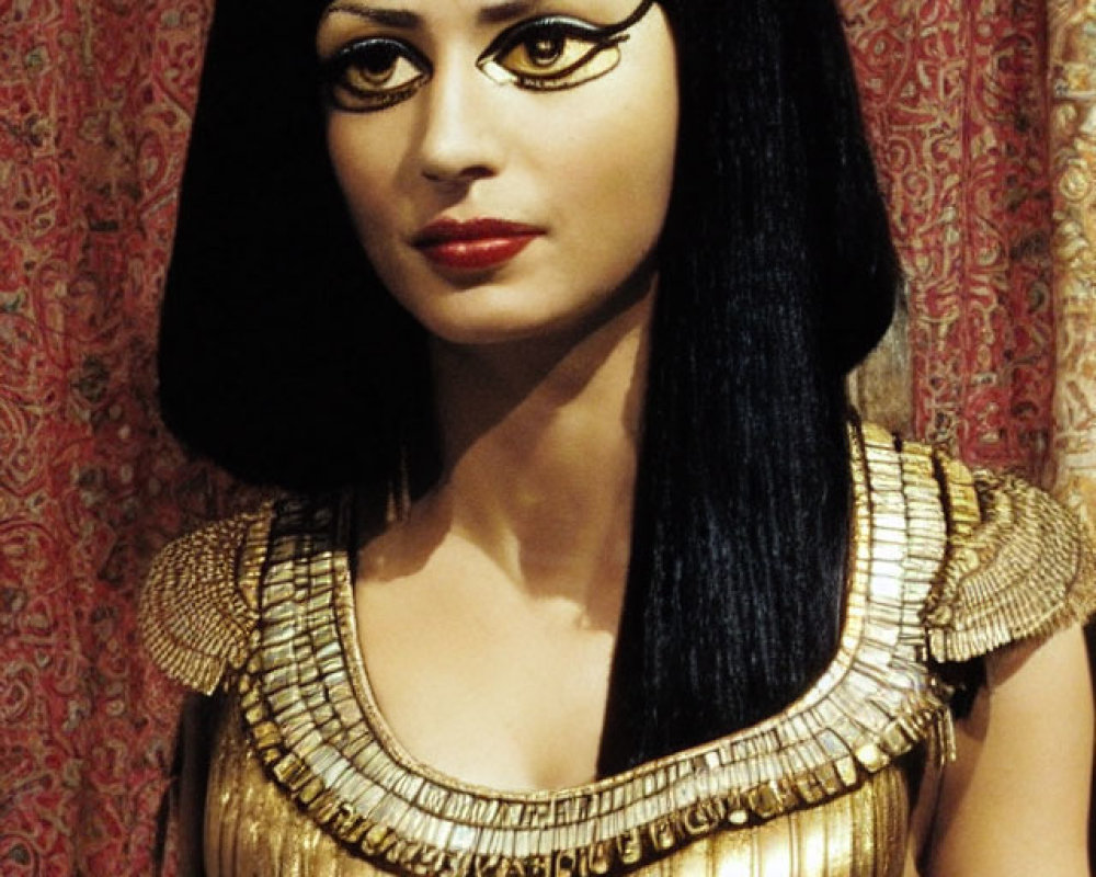 Mannequin in Cleopatra costume with black wig and golden accessories on red backdrop