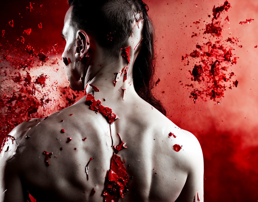 Profile of a person with red paint splatters on back and side.
