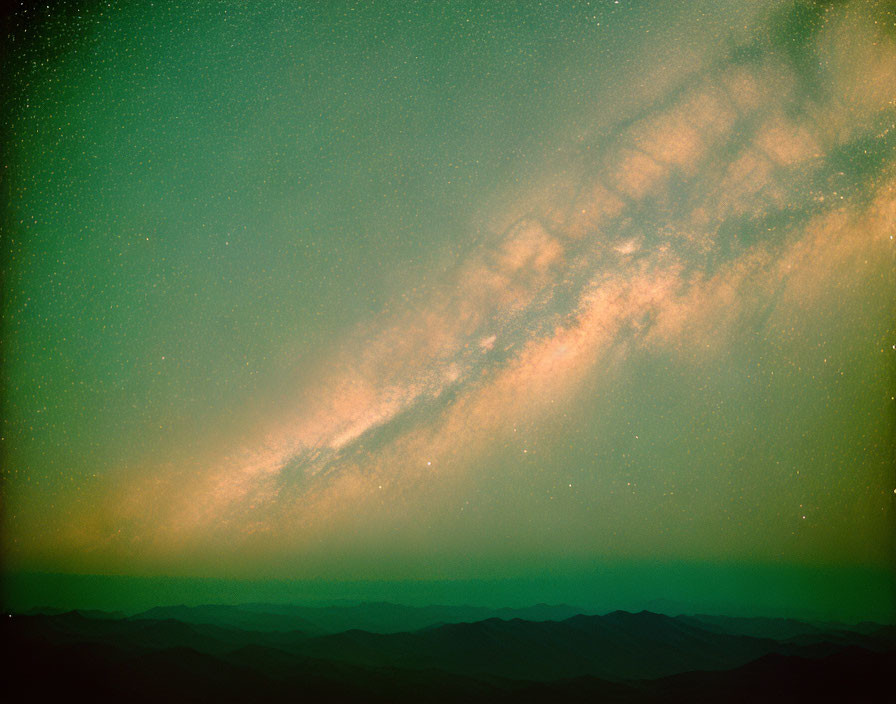 Starry night sky over silhouetted mountains with Milky Way view