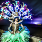 Elaborate neon light tree decorations on woman in night sky