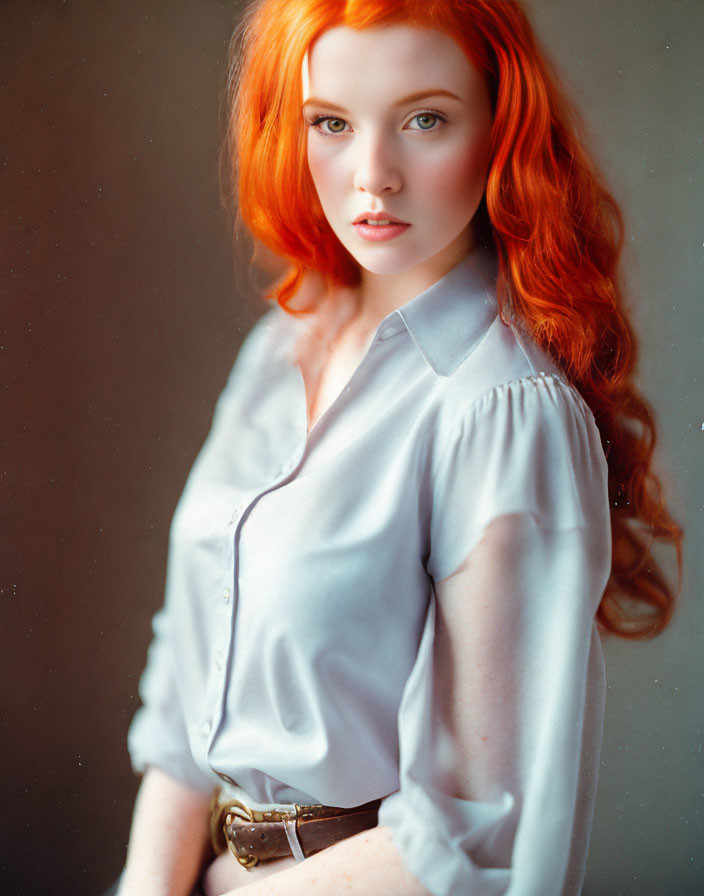 Long Red-Haired Woman in Blue Shirt Poses with Soft Lighting
