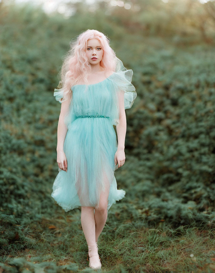 Blonde woman in pastel green tulle dress in serene field
