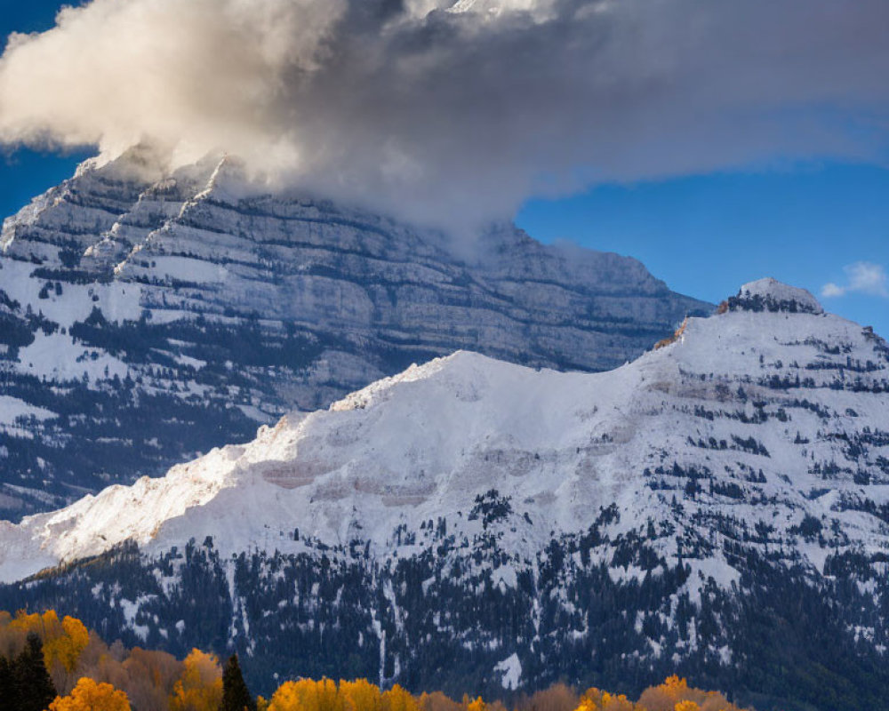 Autumn landscape with snow-capped mountains and dynamic sky