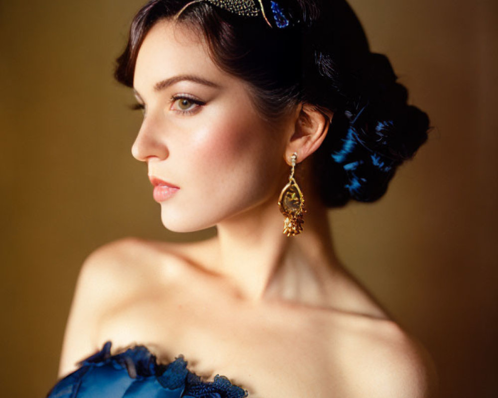 Portrait of woman in blue attire with gold tiara and updo hairstyle