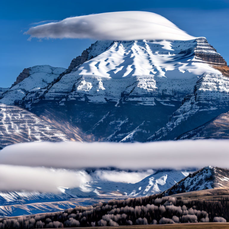 Snow-capped mountain with lenticular clouds and misty layers in blue sky