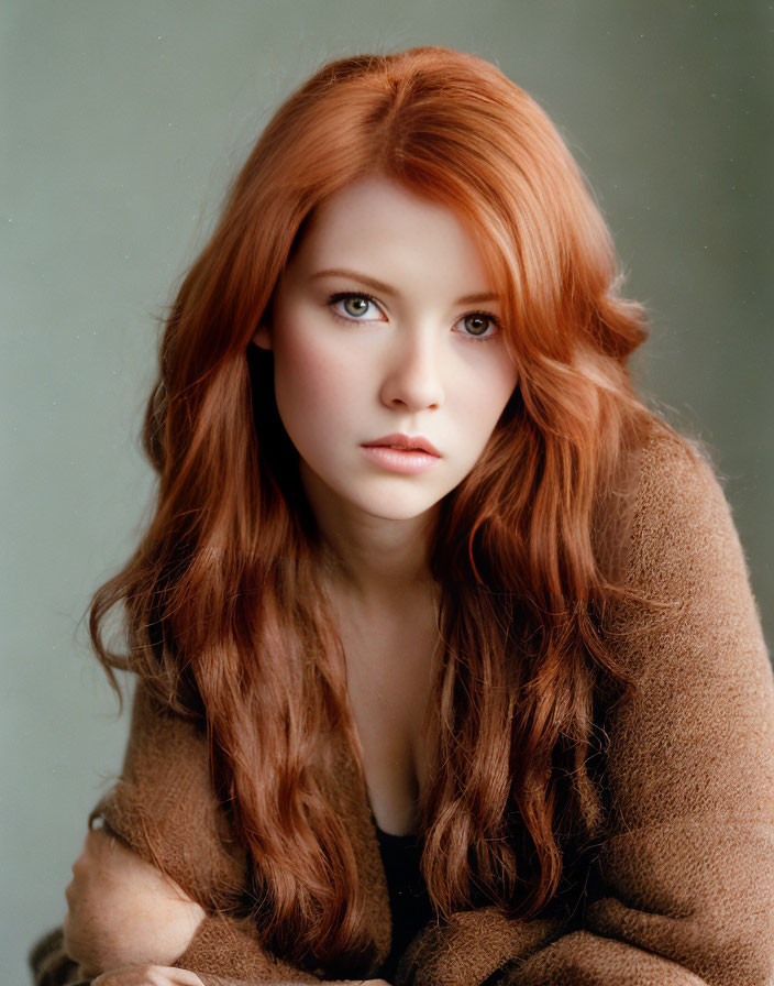 Red-haired woman in brown fuzzy sweater gazes at camera