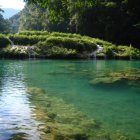 Serene Forest Pond with Turquoise Water and Waterfall