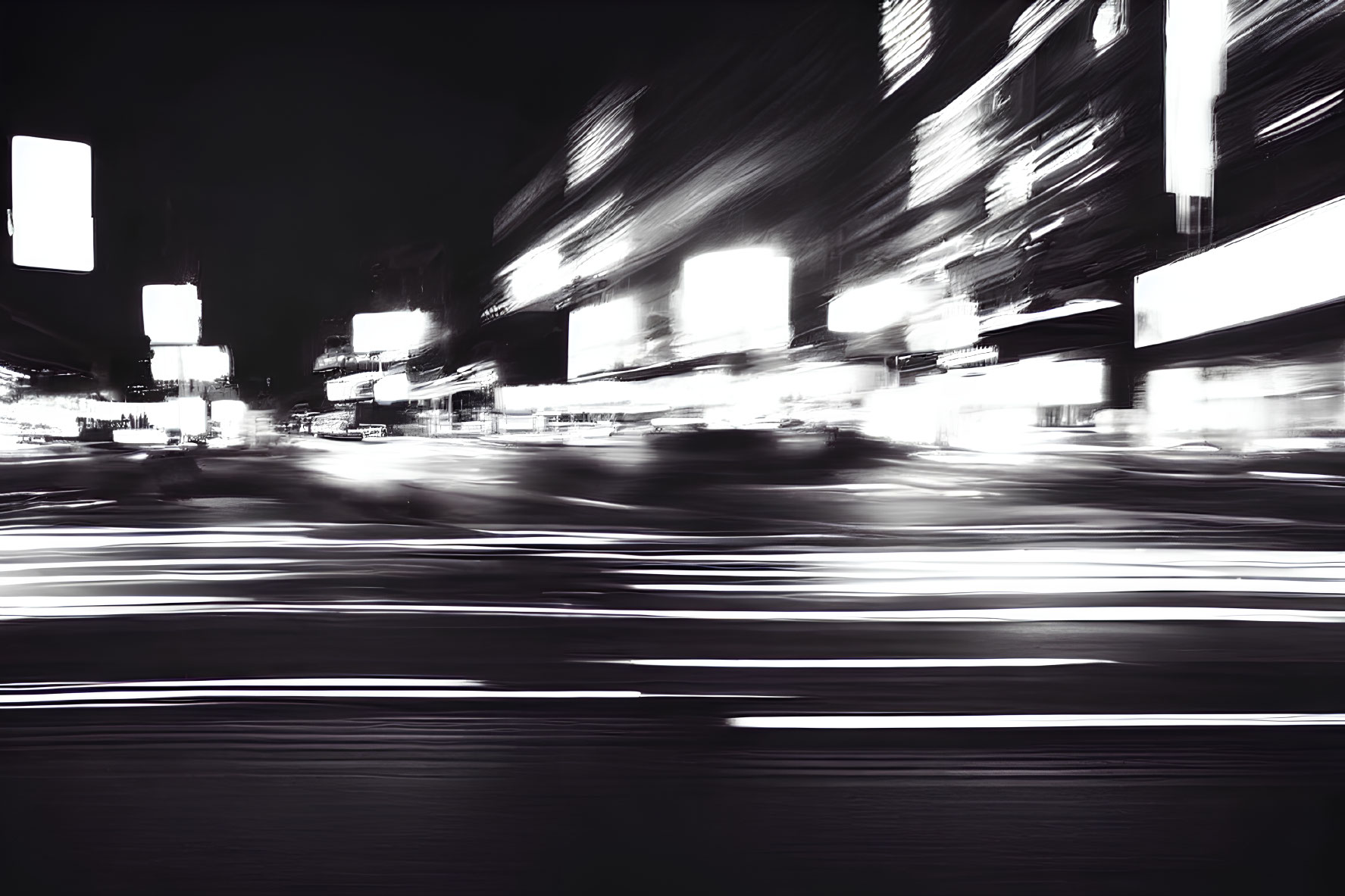 High-contrast black and white city street night scene with motion blur and glowing lights.