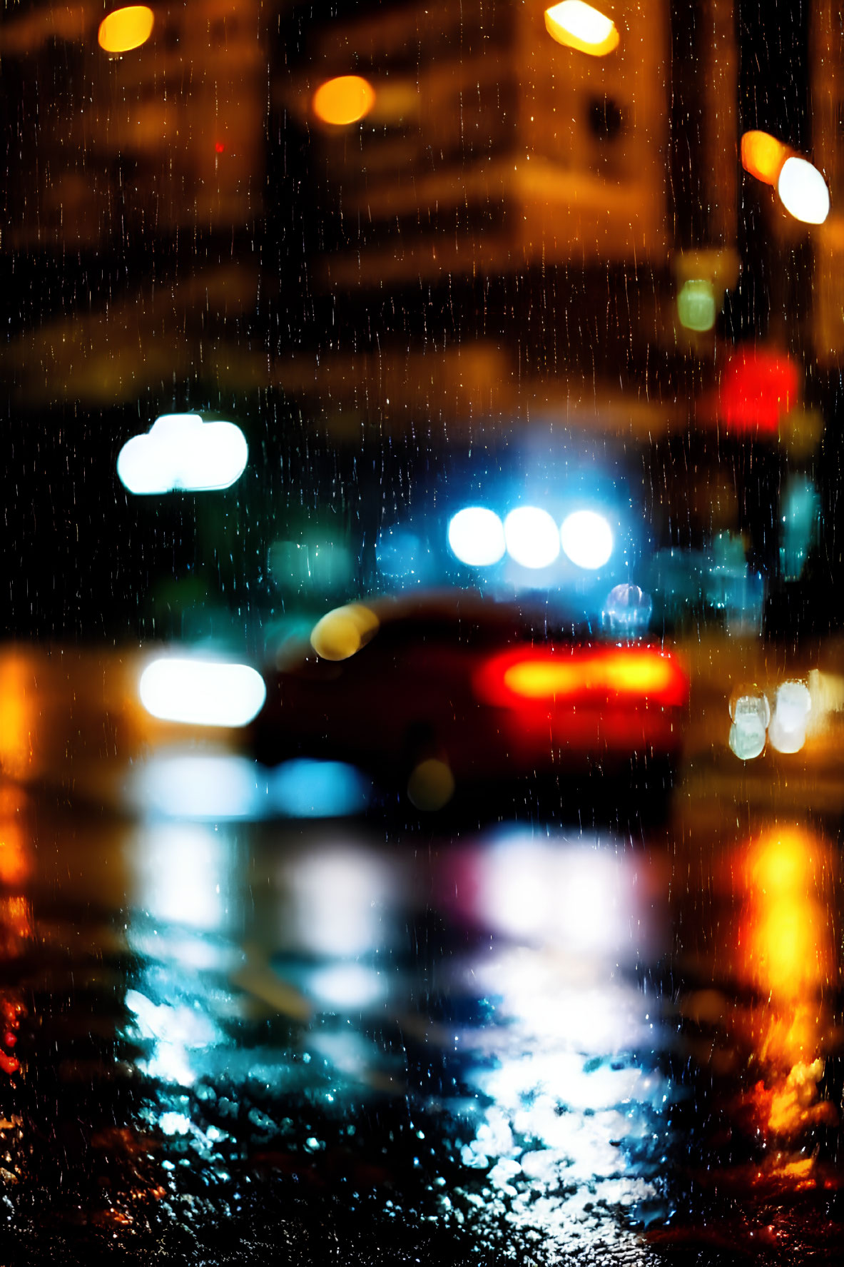 Blurred car tail lights on rain-soaked city street at night