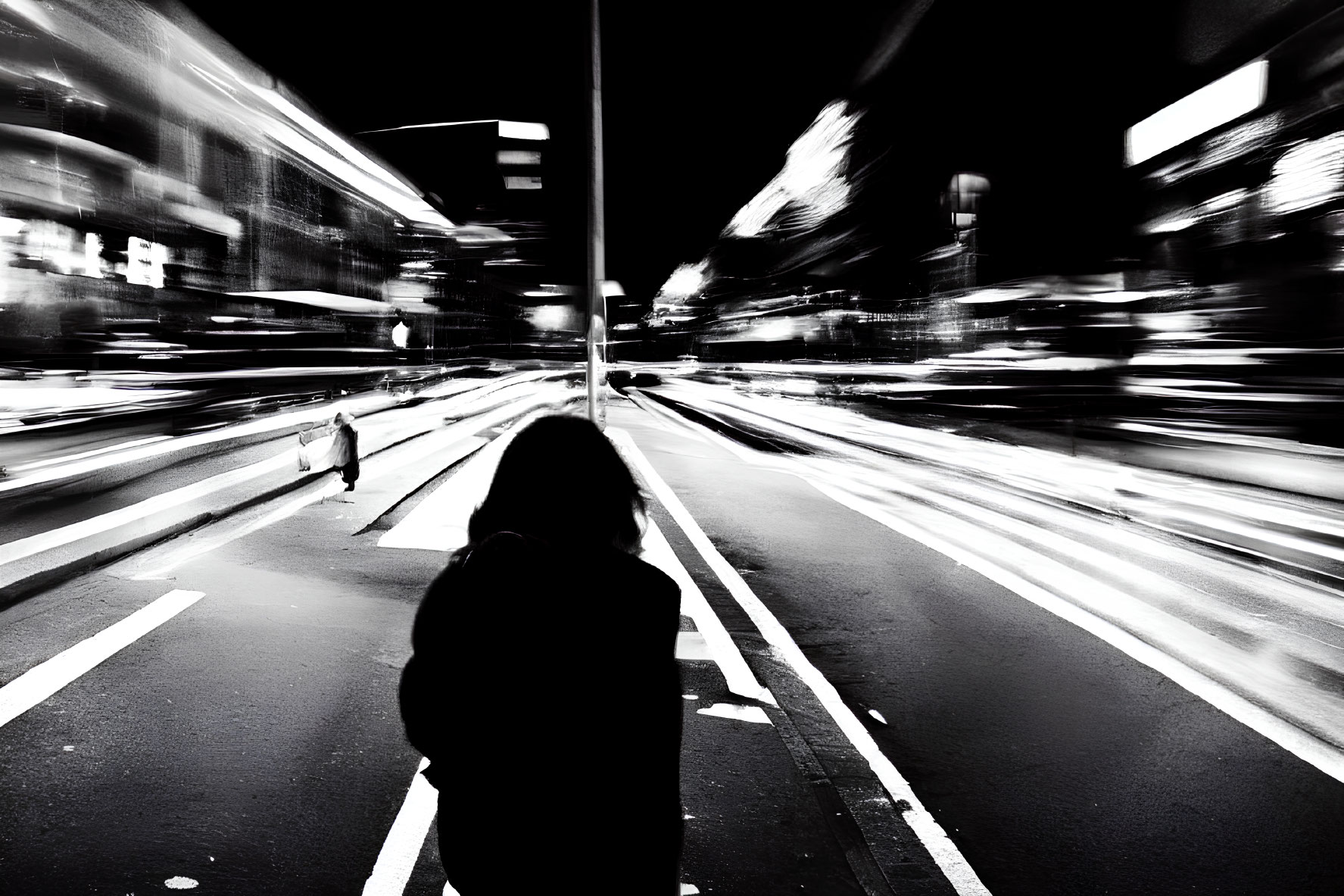 Solitary figure in urban night scene, high-contrast black and white.