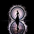 Silhouette of woman by luminous circular portal with dynamic water splashes