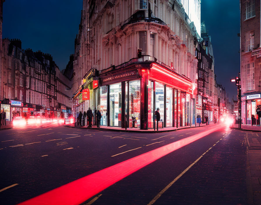 City street corner with vibrant red neon lights and passing traffic.