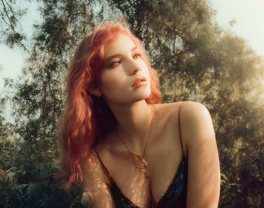 Coral-Haired Woman Contemplating in Greenery Under Sunlight