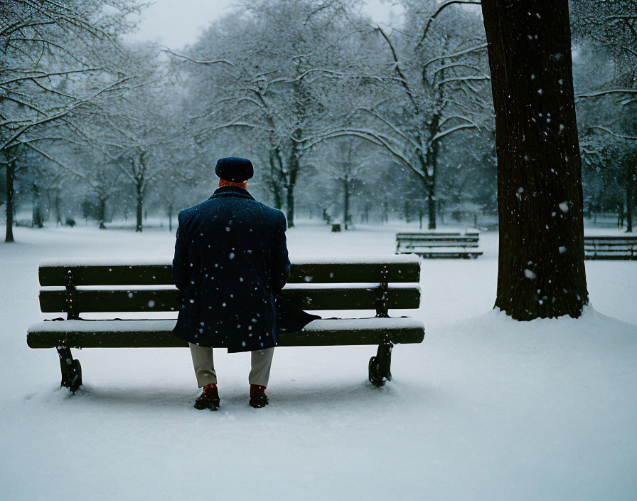 Solitary Figure on Park Bench in Snowy Winter Scene