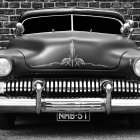 Vintage car with glowing headlights and stylized graphics on "The end" license plate in monochrome against