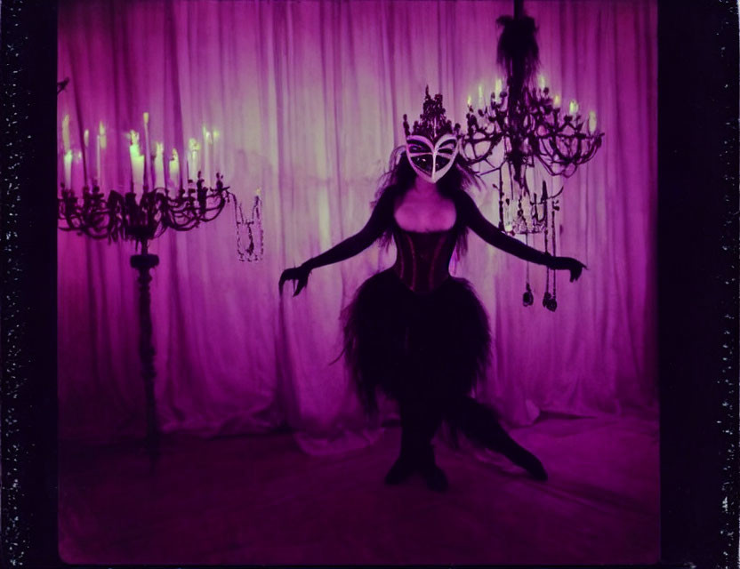 Person in dramatic costume with mask and feathers against purple backdrop with chandeliers.