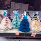 Multiple women in elaborate 18th-century gowns against a whimsical backdrop