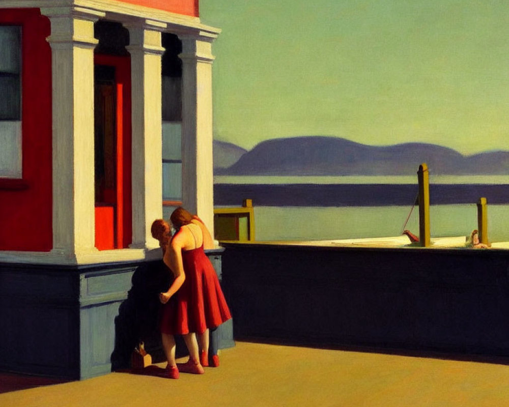 Two women in red dresses chat near building with sea view.