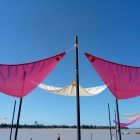 Medieval tent spires with white and red fabric banners under blue sky