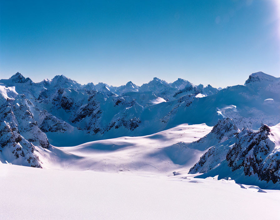 Snow-covered Mountain Range Under Clear Blue Sky - Panoramic View