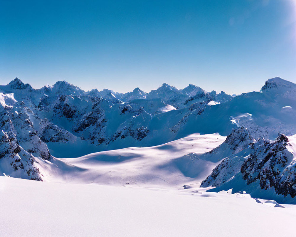 Snow-covered Mountain Range Under Clear Blue Sky - Panoramic View