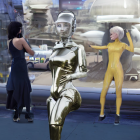 Futuristic image featuring three individuals in blue, shiny suit, and yellow with cityscape.