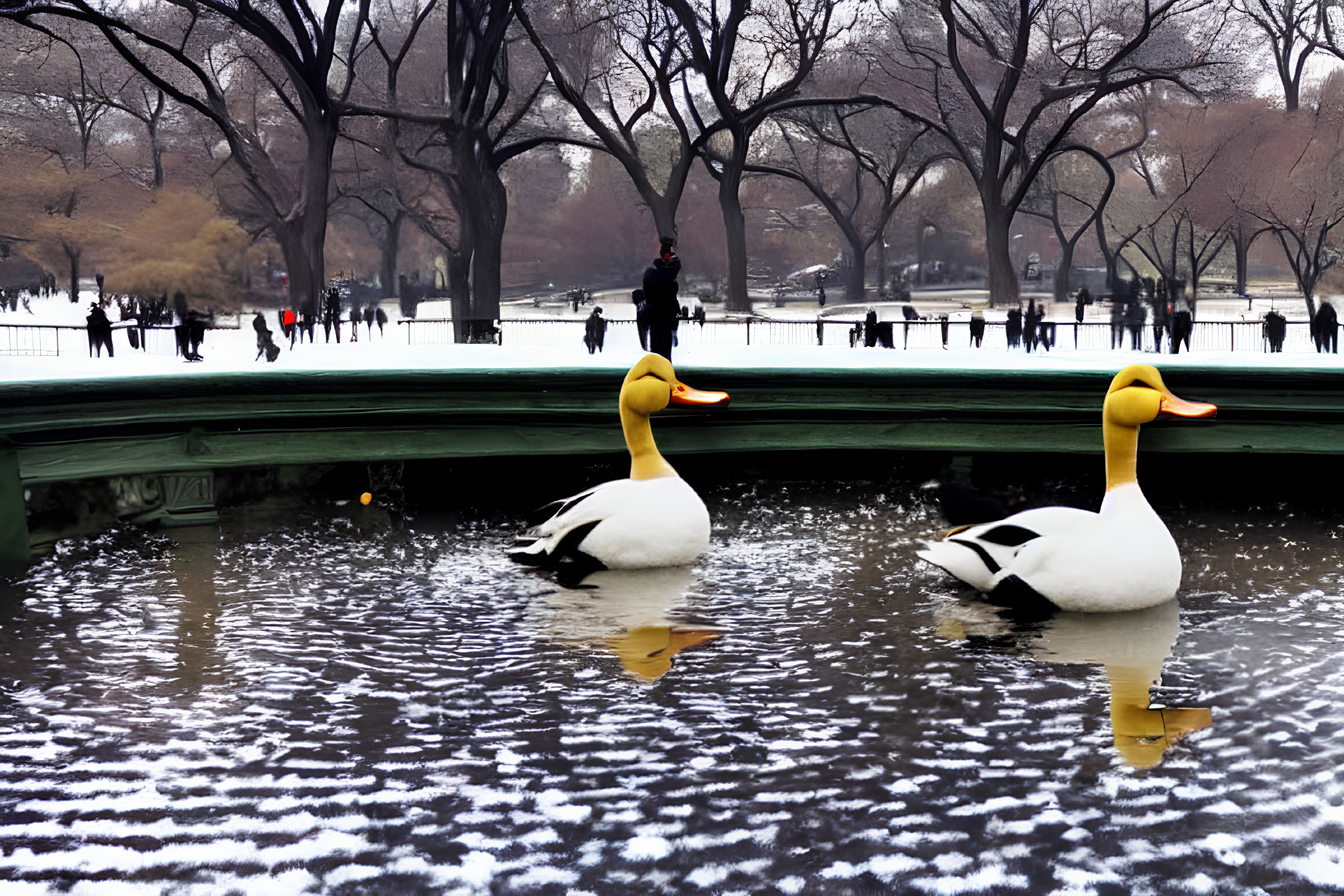 Large Duck Sculptures on Snow-Covered Water with People and Trees
