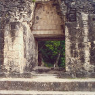 Stone Temple Entrance with Carved Details and Statues on Cliff Face