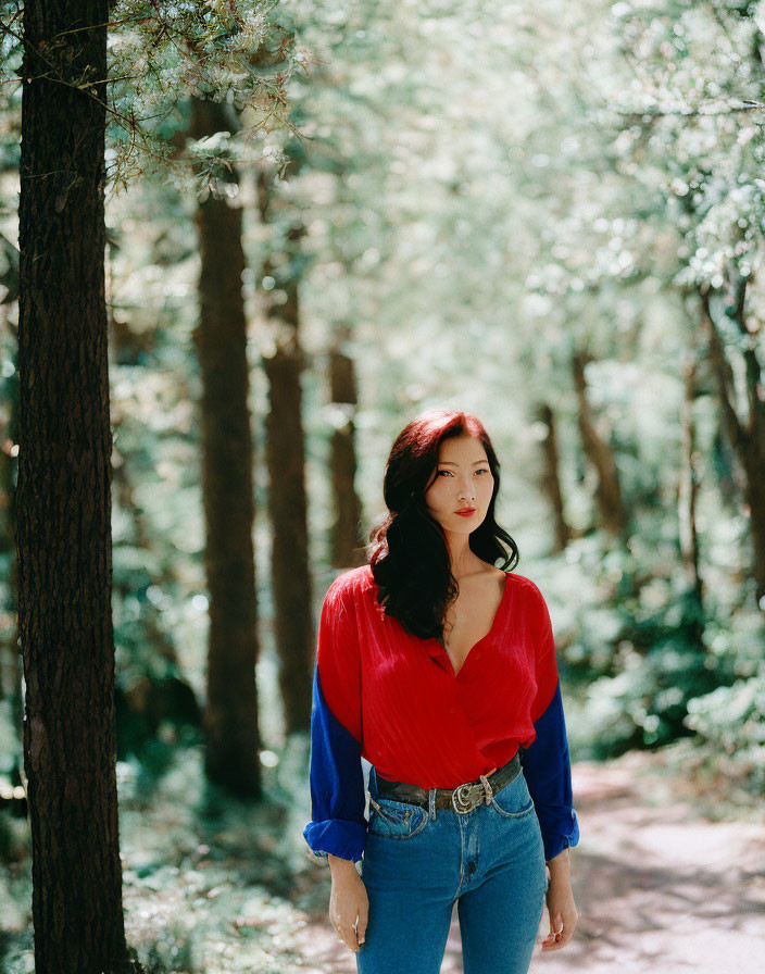 Woman in Red Blouse and Blue Jeans Among Tall Pine Trees
