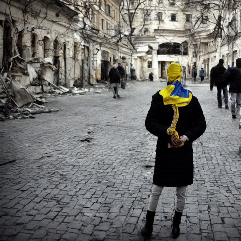 Person in Yellow and Blue Headscarf Amid War-Torn Street