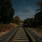 Deserted railroad tracks and old train carriage under dusky starry sky