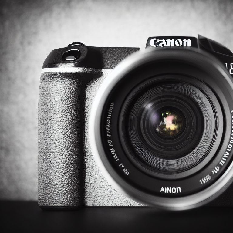 Detailed Close-Up of Canon Camera with Large Lens on Gray Backdrop
