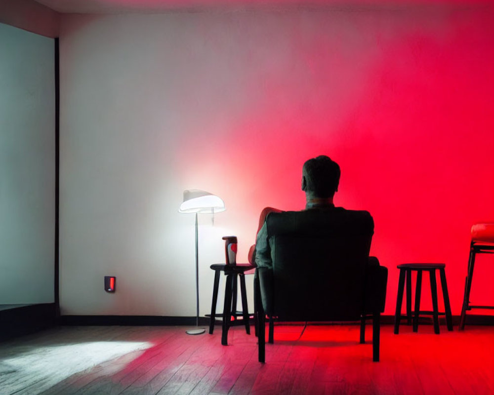 Person in Dark Room with Red Light, Chair, Lamp, and Cup