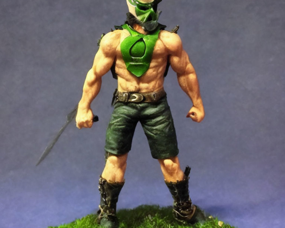 Muscular figurine with green mask and knife on grassy base