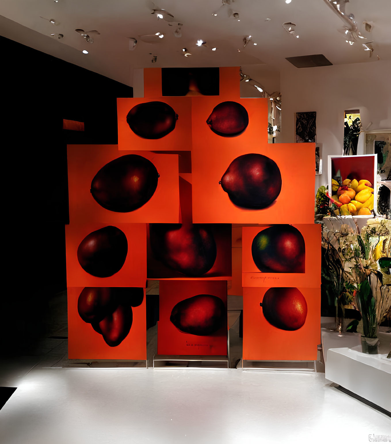 Vivid red apples on orange panels in dimly lit exhibit