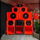 Vintage Red Sound System with Multiple Speakers and Cassette Player illuminated by Warm Lights on Dark Background with Plant