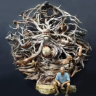 Surreal painting of man's head revealing intricate scenes with altering hands