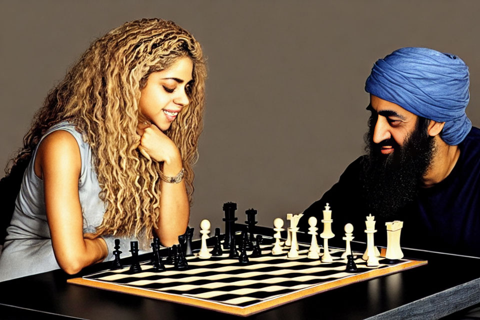 Man and woman playing chess with blue turban and smile.