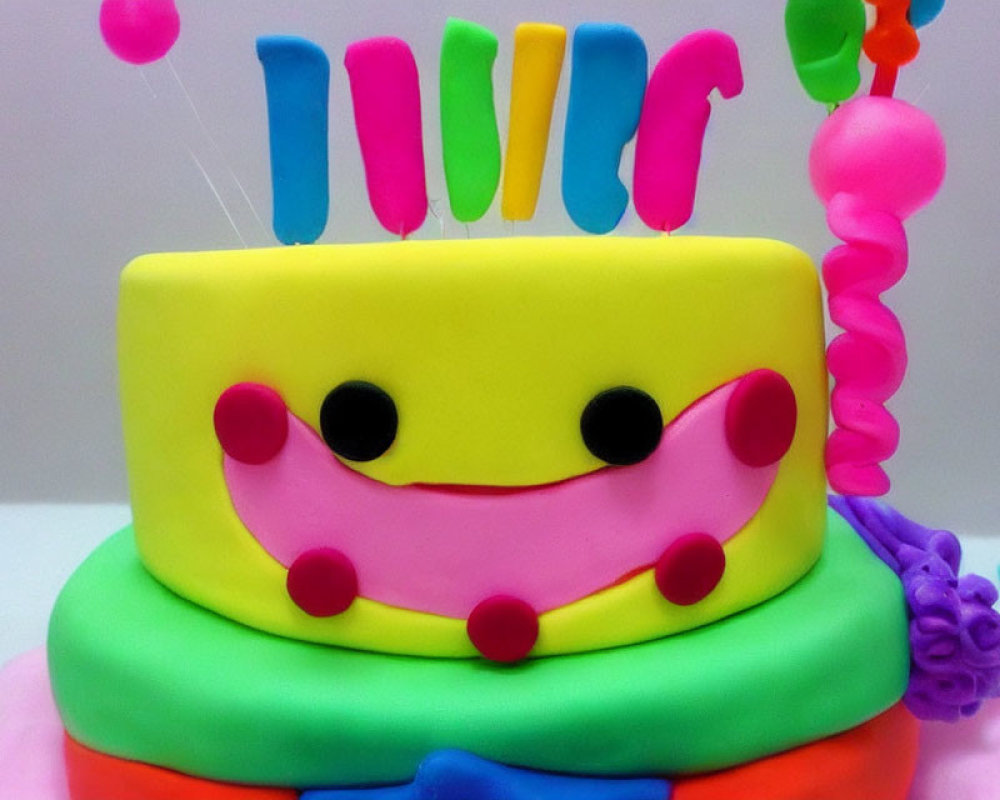 Colorful Two-Tiered Birthday Cake with Smiling Face and Balloons
