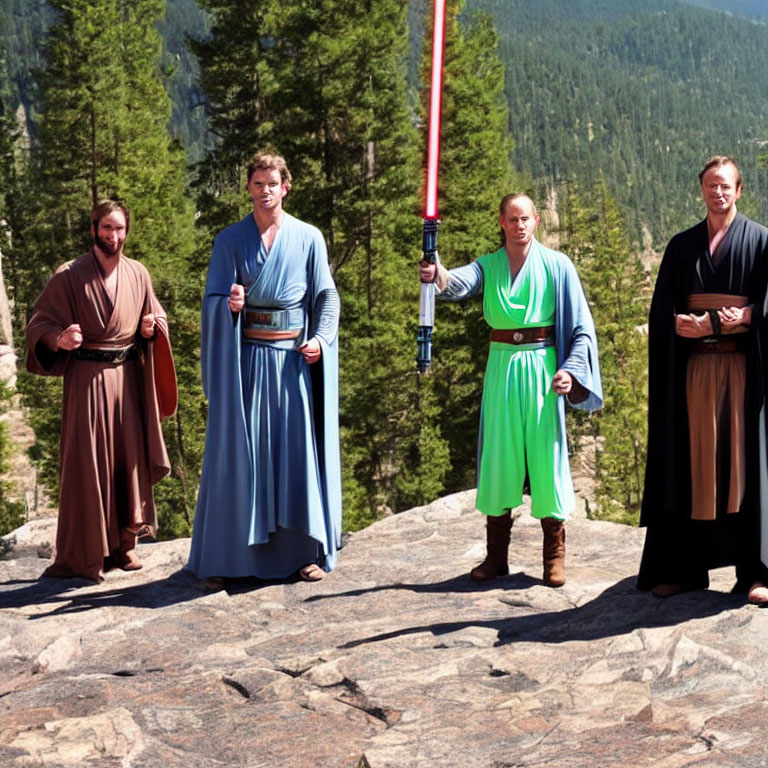 Four people in Star Wars Jedi costumes with lightsabers on rocky landscape with pine trees and clear sky