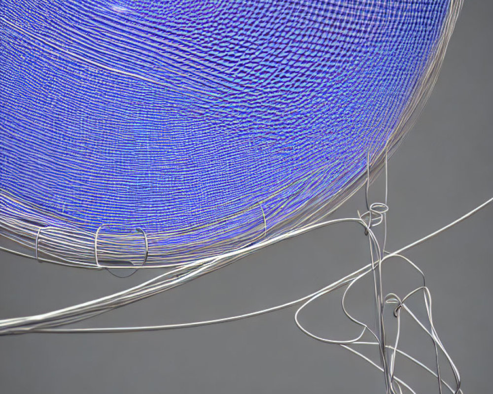 Abstract blue lines swirling to form sphere with white wires in foreground