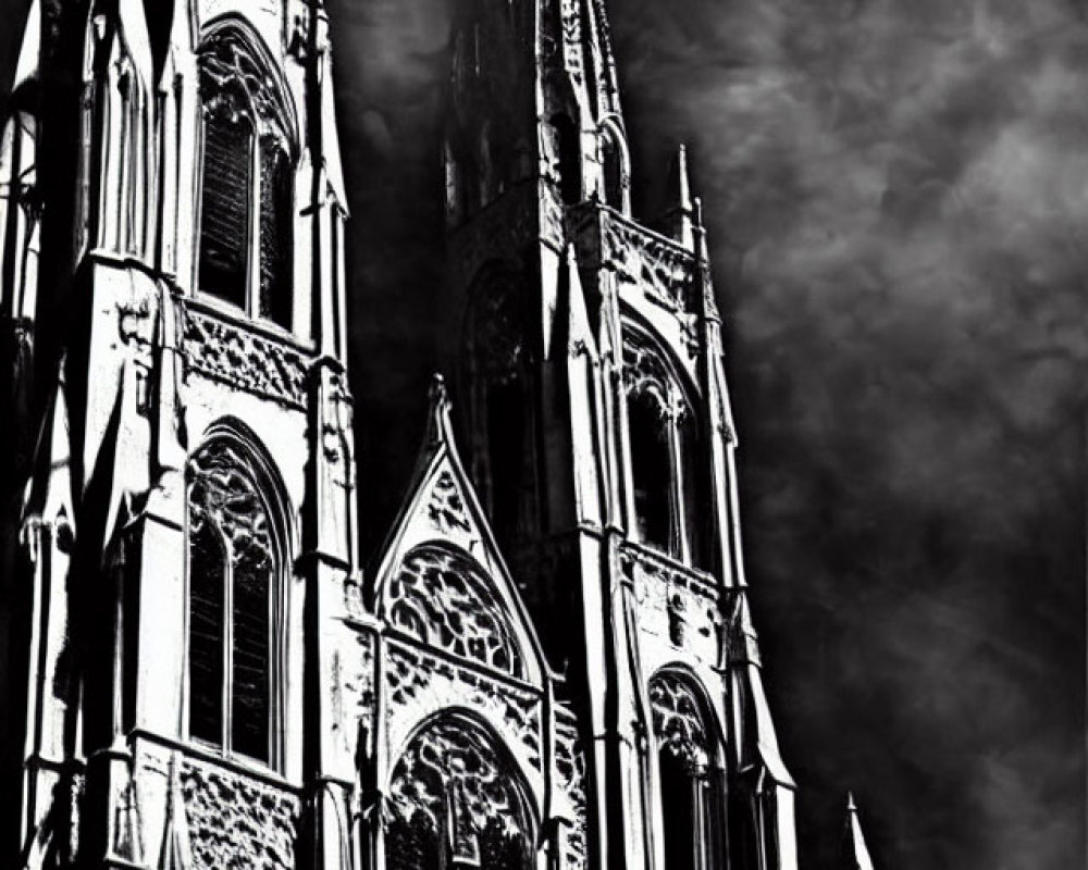Gothic cathedral spires against cloudy sky in high-contrast black and white.