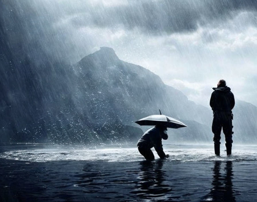 Two individuals in rain with umbrella near mountains.