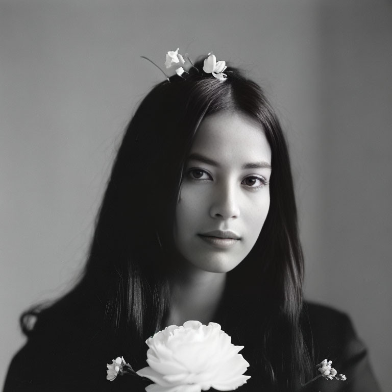 Monochrome portrait of young woman with floral hair accessory
