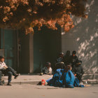 City sidewalk scene with people under autumn trees and scattered belongings